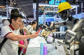 People watch a robot performing tasks at an exhibition during the World AI Conference in Shanghai