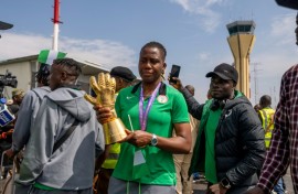 Nigerian goal keeper Chiamaka Nnadozie holds a trophy from the Women's Africa Cup of Nations (WAFCON) as she is welcomed by officials at the Nnamdi Azikiwe International Airport in Abuja