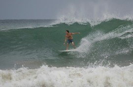 A surfer rides a wave at La Pared beach as Hurricane Erin approaches in Luquillo, Puerto Rico