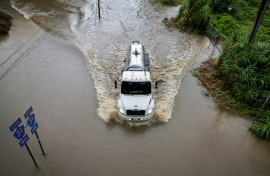 A truck drives through a road in Naguabo, Puerto Rico that was hit by flooding from Hurricane Erin