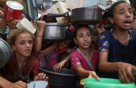 Palestinian children gather to receive cooked meals from a food distribution centre in the Nuseirat refugee camp in central Gaza