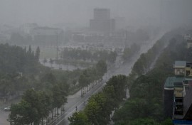 Rain falls above the buildings and a street in Vinh city on August 25, 2025, before Typhoon Kajiki makes landfall in Vietnam