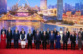 In this photograph distributed by the Russian state agency Sputnik, Russia's President Vladimir Putin, Chinese President Xi Jinping, his wife and foreign leaders pose during the Shanghai Cooperation Organization (SCO) Summit
