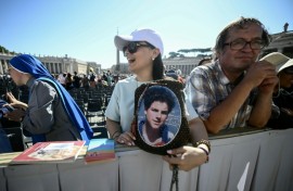 A faithful holds a portrait of Carlo Acutis during a Jubilee audience at the St Peter's Square on Saturday