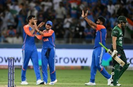 Pakistan captain Salman Agha (R) walks back to the pavilion after his dismissal by Axar Patel (L)