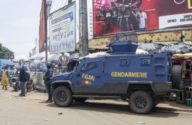 A gendarme stands guard next to an armoured vehicle in Conakry ahead of Guinea's constitutional referendum