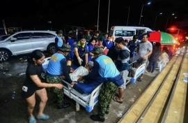 Police assist injured residents as they are brought to the hospital in Bogo City, Cebu province, central Philippines