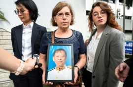 The trial began just three days ago with an examination of witnesses, including Lim Kimya's widow, Anne-Marie Lim (centre, holding a photo of Lim Kimya)