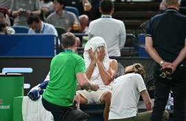 Novak Djokovic wipes his face as he receives medical attention