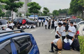 Employees at a shopping mall gather outside the building in Davao City, on the southern island of Mindanao after a 7.4-magnitude earthquake struck off the southern Philippines