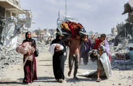 People carried children and belongings as they made their way through the rubble of destroyed buildings to return home