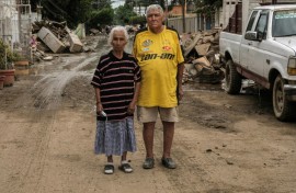 Hilario Reynosa and his wife Elodia Reyes, who survived the flooding in the Morelos neighborhood after being trapped by the overflowing Cazones River, pose for a portrait on a street covered by debris in Poza Rica, Mexico