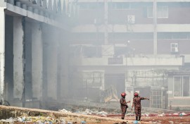 Firefighters inspect the fire-damaged cargo terminal of Hazrat Shahjalal International Airport in Dhaka on October 19, 2025, a day after the blaze
