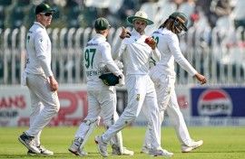 South Africa's Keshav Maharaj (C) gestures as he celebrates after taking his seventh wicket