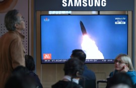 People at a train station in Seoul watch footage of a North Korean missile test