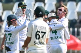 South Africa's Simon Harmer (R) celebrates with teammates after taking the wicket of Pakistan's Noman Ali