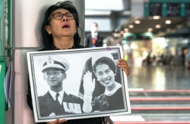 Thai mourner Kanjana Malaithong holds a portrait former queen Sirikit and king Bhumibol Adulyadej as she weeps at Chulalongkorn Hospital in Bangkok