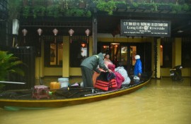 People are evacuated from a hotel by boat in flood waters following heavy rains in Hoi An