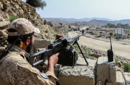 A Taliban security personnel stands guard along a road near the Ghulam Khan zero-point border crossing between Afghanistan and Pakistan