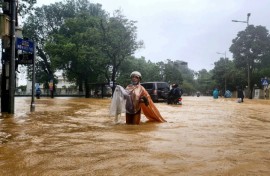 Flooding triggered by record heavy rain has killed at least four people and inundated more than 100,000 homes in central Vietnam, the environment ministry said