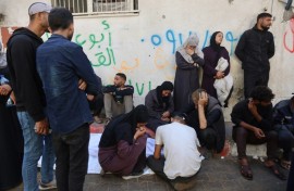 Palestinians mourn over the body of a relative who was killed in overnight Israeli strikes
