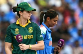 South Africa's captain Laura Wolvaardt (L) and India's skipper Harmanpreet Kaur prepare for interviews after the World Cup final coin toss