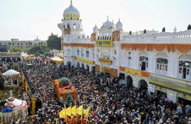 As the procession spilled into the streets, Muslims came out onto rooftops, showering Sikh pilgrims with rose petals