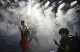 People walk under a misting system on a hot day in Tokyo earlier this year, which is on track to become one of the hottest in recorded history, according to the UN