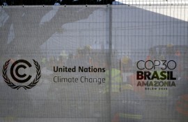 Workers rest behind a fence bearing the COP30 logo at a construction site in the City Park of the COP30, the United Nations Climate Change Conference in Belem, Para State, Brazil on November 3, 2025