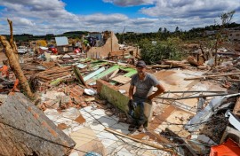 Nereu Sabadini sits on the debris of his house that was destroyed by a tornado in Rio Bonito do Iguaçu, Brazil