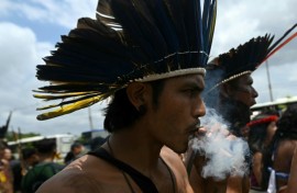 A Munduruku Indigenous man of the Ipereg Ayu movement smokes during a protest outside the COP30 UN Climate Change Conference in Belem