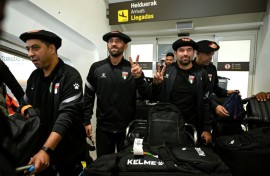 Palestinian national football team members wear the traditional Basque "txapela" (beret) as they arrive at Bilbao airport ahead of a match against the Basque national team