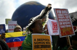 Indigenous people hold signs reading "The answer is us" and "End of fossil fuels, no mining in our territories" during a march on the sidelines of the COP30 UN Climate Change Conference in Belem, Brazil
