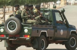 Men in military uniforms patrol the main road leading to Guinea-Bissau's presidential palace after heavy gunfire was heard