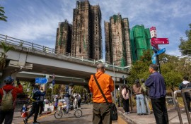 People look at the aftermath of a major fire that swept through several apartment blocks at the Wang Fuk Court residential estate