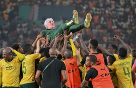 Coach Hugo Broos (C) is lifted as South Africa celebrate winning the 2024 Africa Cup of Nations third-place play-off against the Democratic Republic of Congo.