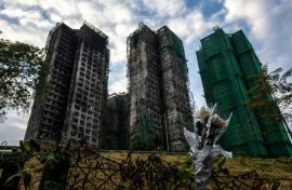 Flowers are seen in front of the Wang Fuk Court apartment blocks in the aftermath of the deadly November 26 fire in Hong Kong's Tai Po district on December 3, 2025