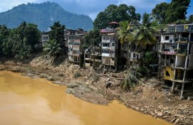 Uprooted trees lie along damaged buildings following a landslide in Gampola town, Kandy district, on December 4, 2025