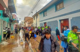 Police and residents try to extinguish a fire in a restaurant in the Peruvian town of Huancane that killed 10 students