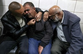 Palestinians try to console the father of Bahaa Abdel-Rahman Rashid at the nearby city of Nablus' Rafidia hospital