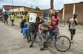Lines of civilians crossed the border, watched by Rwandan police