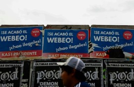 A person walks past posters supporting Chilean presidential candidate Jose Antonio Kast of the Republican Party in Santiago