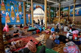 Residents rest inside a temple after they evacuated following clashes along the Cambodia-Thailand border, in Siem Reap province