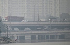 Vehicles drive on a highway during heavy air pollution in Hanoi on December 11, 2025