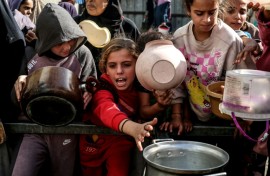 Displaced Palestinian children waited for food at a shelter in Nuseirat, Gaza, in November 2025