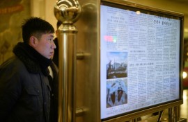A man reads North Korea's Rodong Sinmun newspaper on a digital monitor at a metro station in Pyongyang