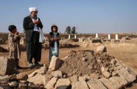 Gul Ahmad (centre) along with his deceased stepbrother Habibullah's son Waheed (right) and Saeed offering prayers over his grave in Ghunjan