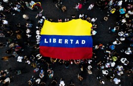 Venezuelans living in Argentina display a Venezuelan flag that reads "Freedom" as they celebrate the toppling of strongman Nicolas Maduro