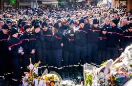 Firefighters from the Municipality of Crans-Montana gathered around a makeshift memorial to pay their respects