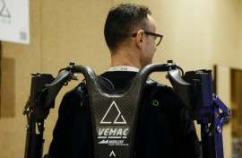 An exhibitor displays AGADE's Agadexo Lowback, its next-generation AI-driven industrial exoskeleton